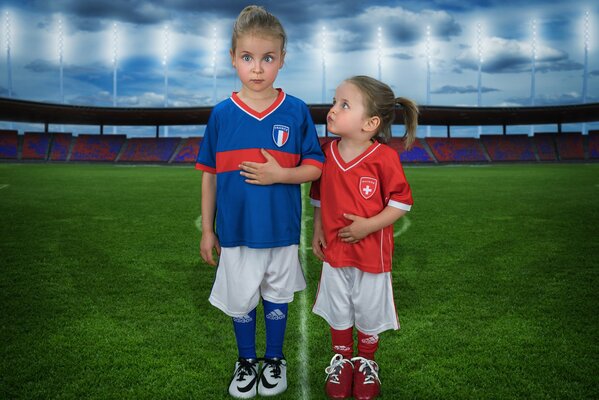 Small children in sports uniforms on the football field