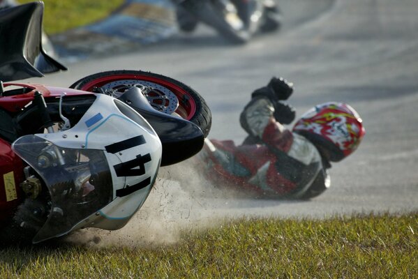 The fall of a rider from a motorcycle at a race