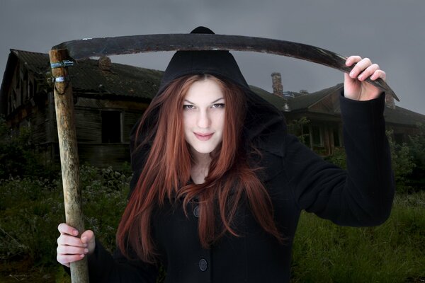 A girl with a scythe on the background of an abandoned building