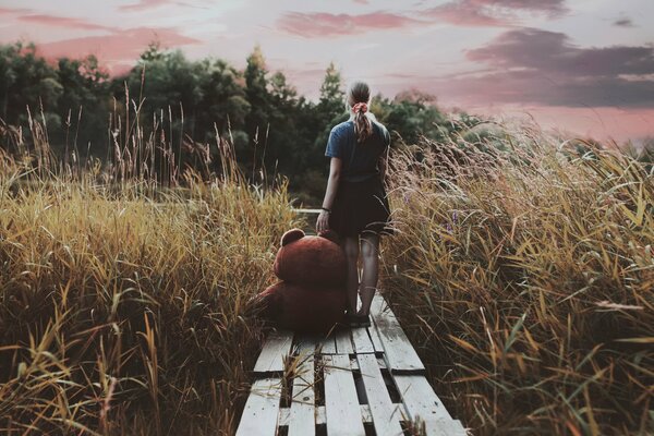 A girl with a bear by the river