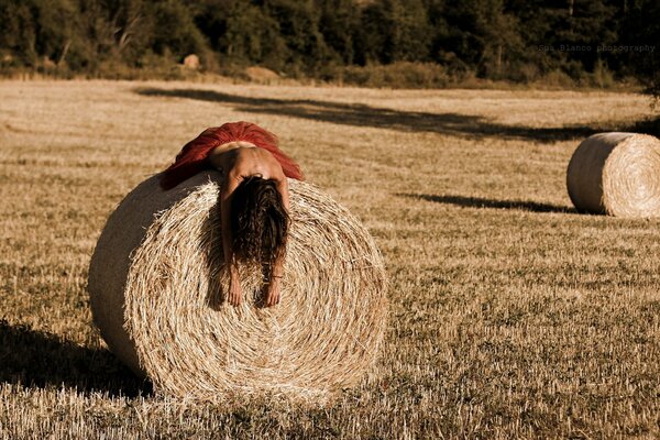 Fille se trouve sur une botte de foin