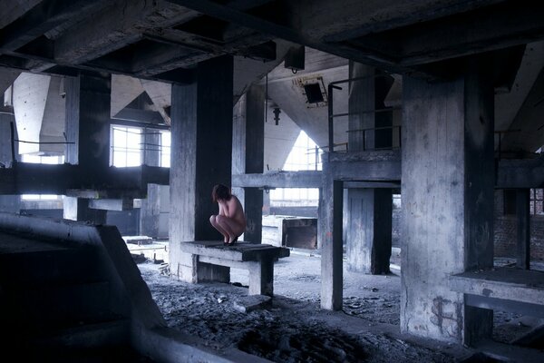 Chica desnuda en un edificio abandonado