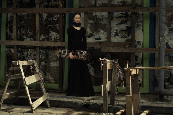 Fille en robe noire avec planche à roulettes dans les mains