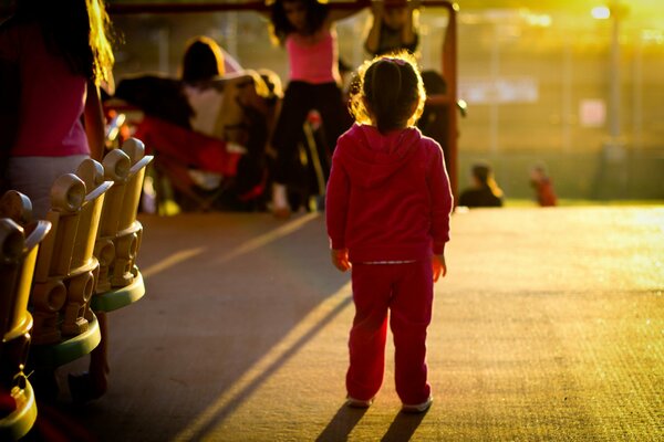 A little girl in a pink tracksuit