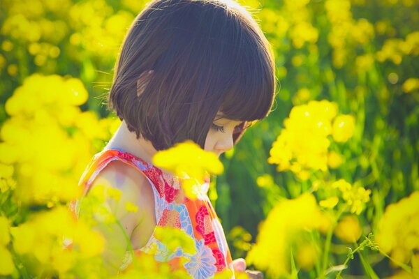 Niña de verano en el campo con flores