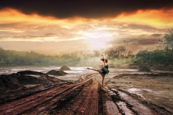 A girl dancing on the road in the rain. Orange sunset