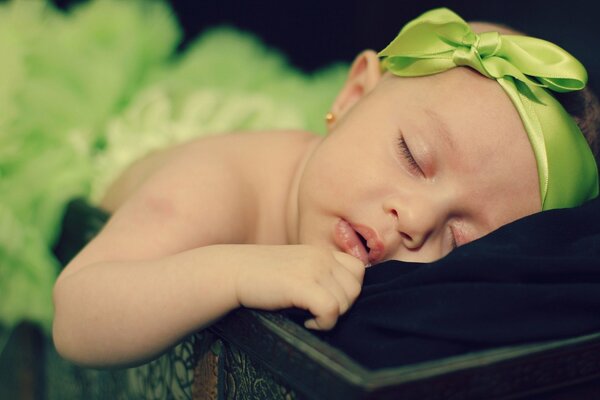 Douce fille avec un arc vert dort