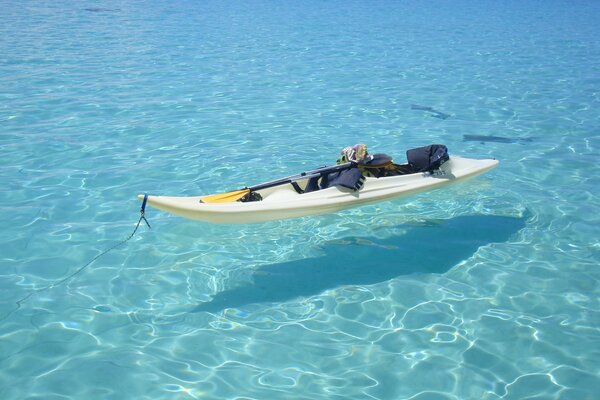 Boat with paddle in crystal clear water