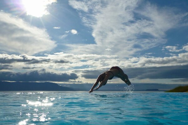 The girl jumps out of the water like a dolphin