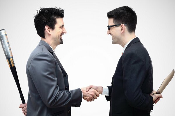 Two men shake hands and hold weapons behind their backs