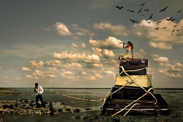 A guy drags a girl sitting on suitcases