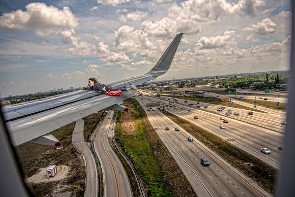 The girl clung to the wing of the plane