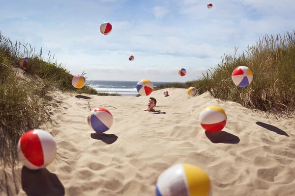 A lot of balls jump to the guy buried in the sand