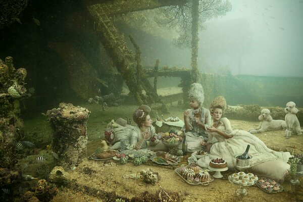 Chicas con vestidos hicieron un picnic en el fondo del lago