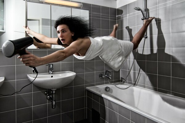 Brunette in the bathroom with a hairdryer