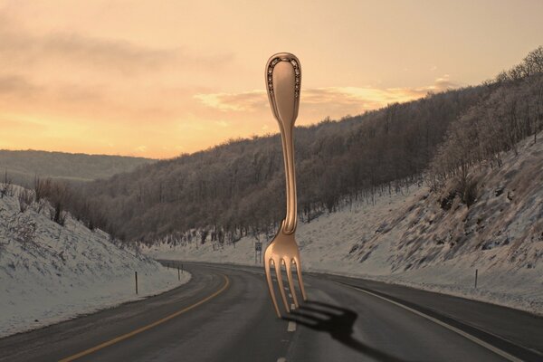 Tenedor de plata en medio de la carretera y el bosque nevado