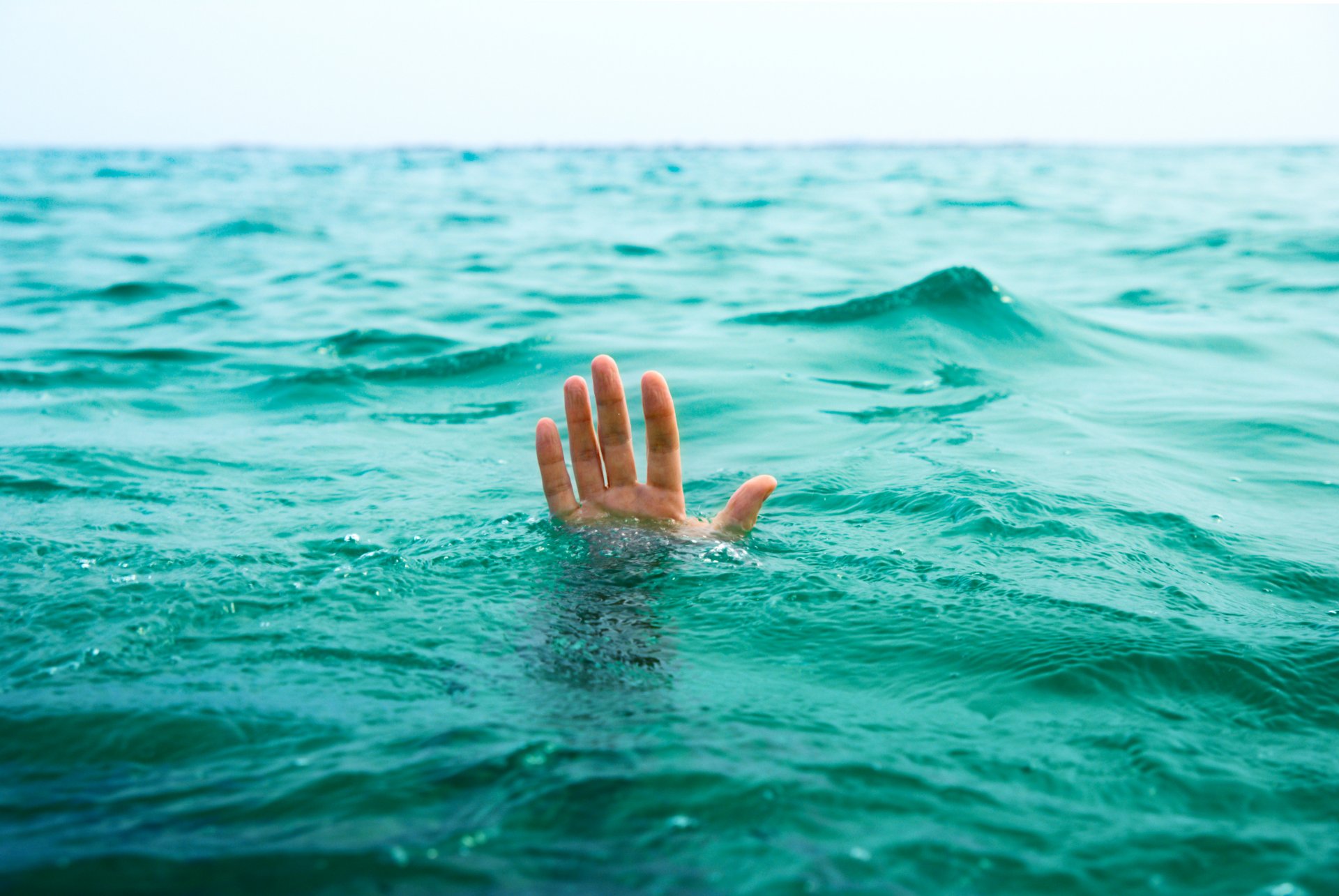 ituation guy hand sinks sea ocean water help death life