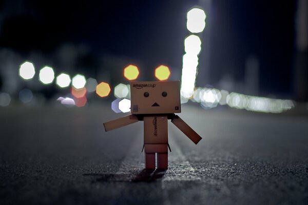 Danbo is a cardboard man wandering along a night highway lit by lights