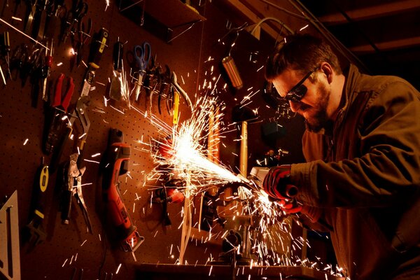 A man with glasses works with a tool