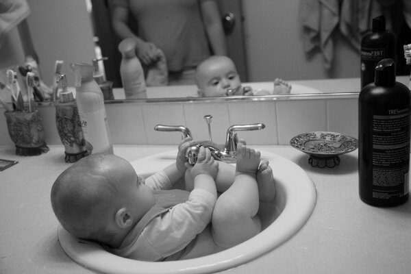 Baby bathes in the sink cute