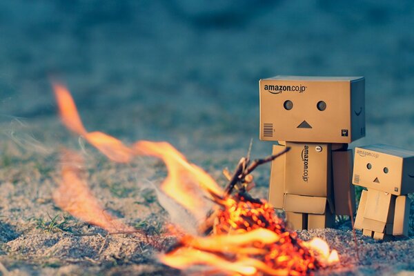 Ein paar Danbo-Pappmenschen, die sich am Lagerfeuer wärmen