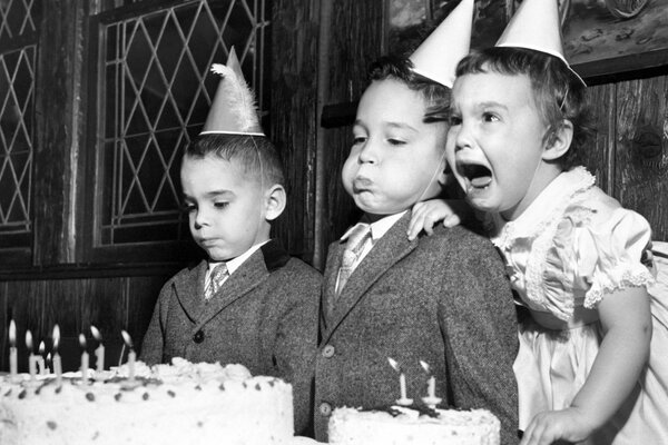 Children blow out candles on a birthday cake