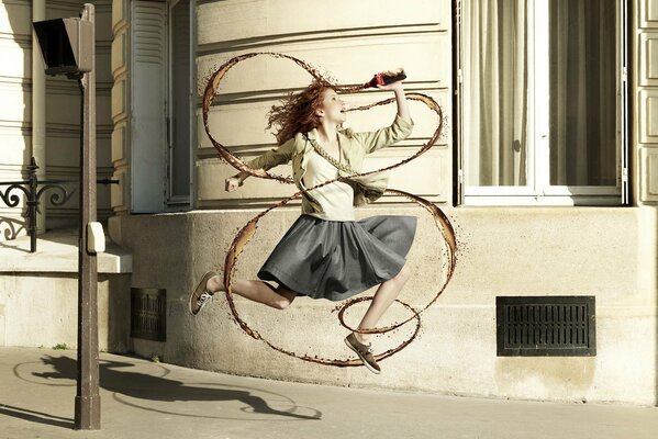 The girl jumps with a bottle in her hands