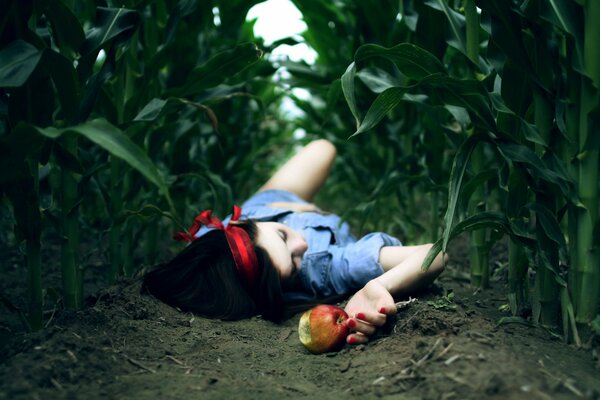 A girl with an apple lying in a field