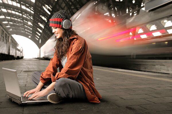 The girl is texting on the station platform