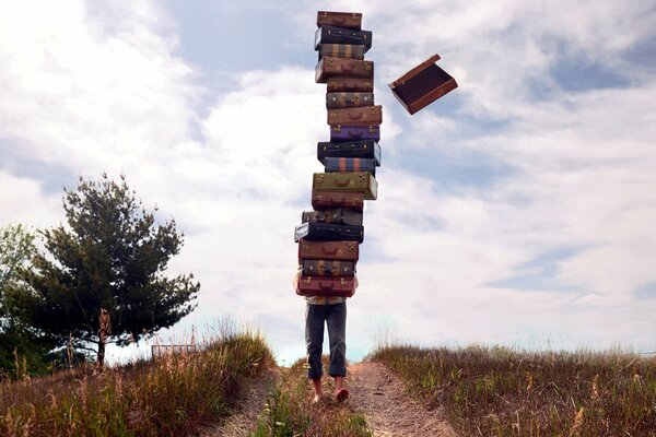 A man walks down the road with a bunch of suitcases