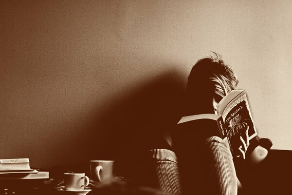 Cozy photo of a reading man with a cup of coffee