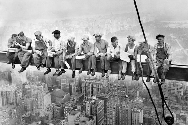 Con una pausa para el almuerzo. Trabajadores fuman en una viga