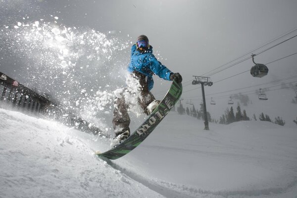 Zdjęcie snowboardzisty na tle kolejki linowej