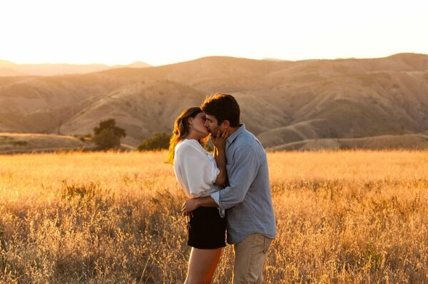 Pareja joven besándose en medio de un campo de trigo