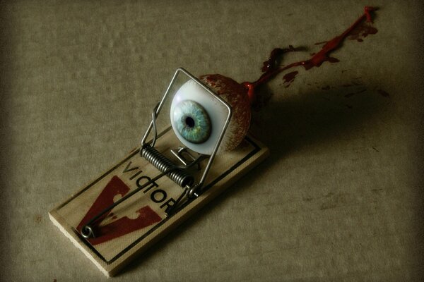 A bloody eye trapped in a mousetrap