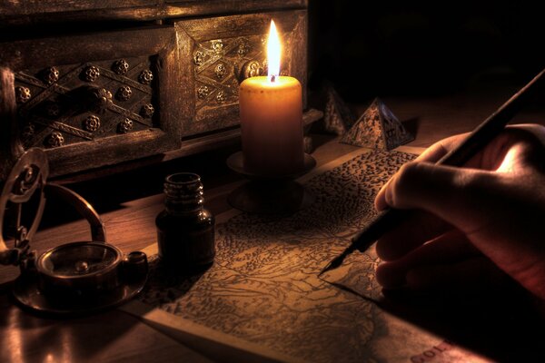 A man writes with a pen by candlelight