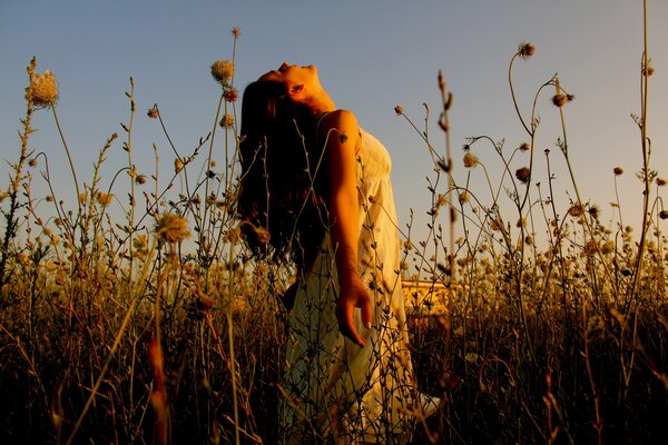 A girl in a field at sunset