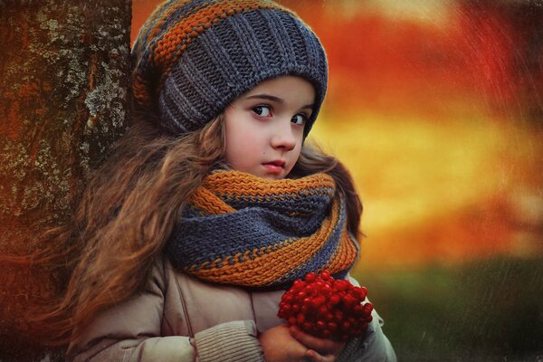 The girl picked berries and leaned against a tree