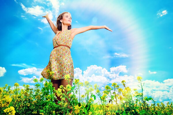 Mädchen in einem Feld mit Blumen auf einem Regenbogen-Hintergrund