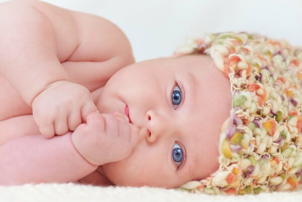 Baby mit blauen Augen in einer farbigen Mütze