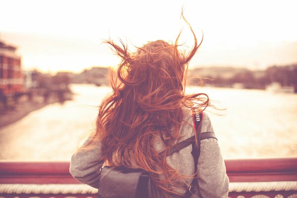 A girl with red hair in windy London