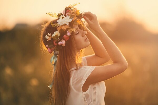 A young maiden in a wreath of summer flowers