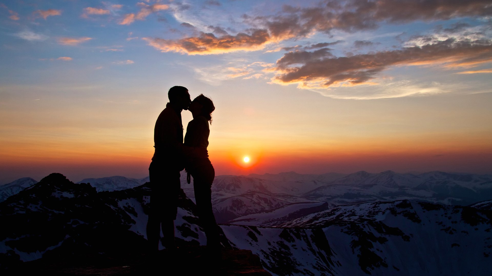 amor beso abrazo chica niño mujer hombre puesta de sol sol montañas nieve nubes cielo