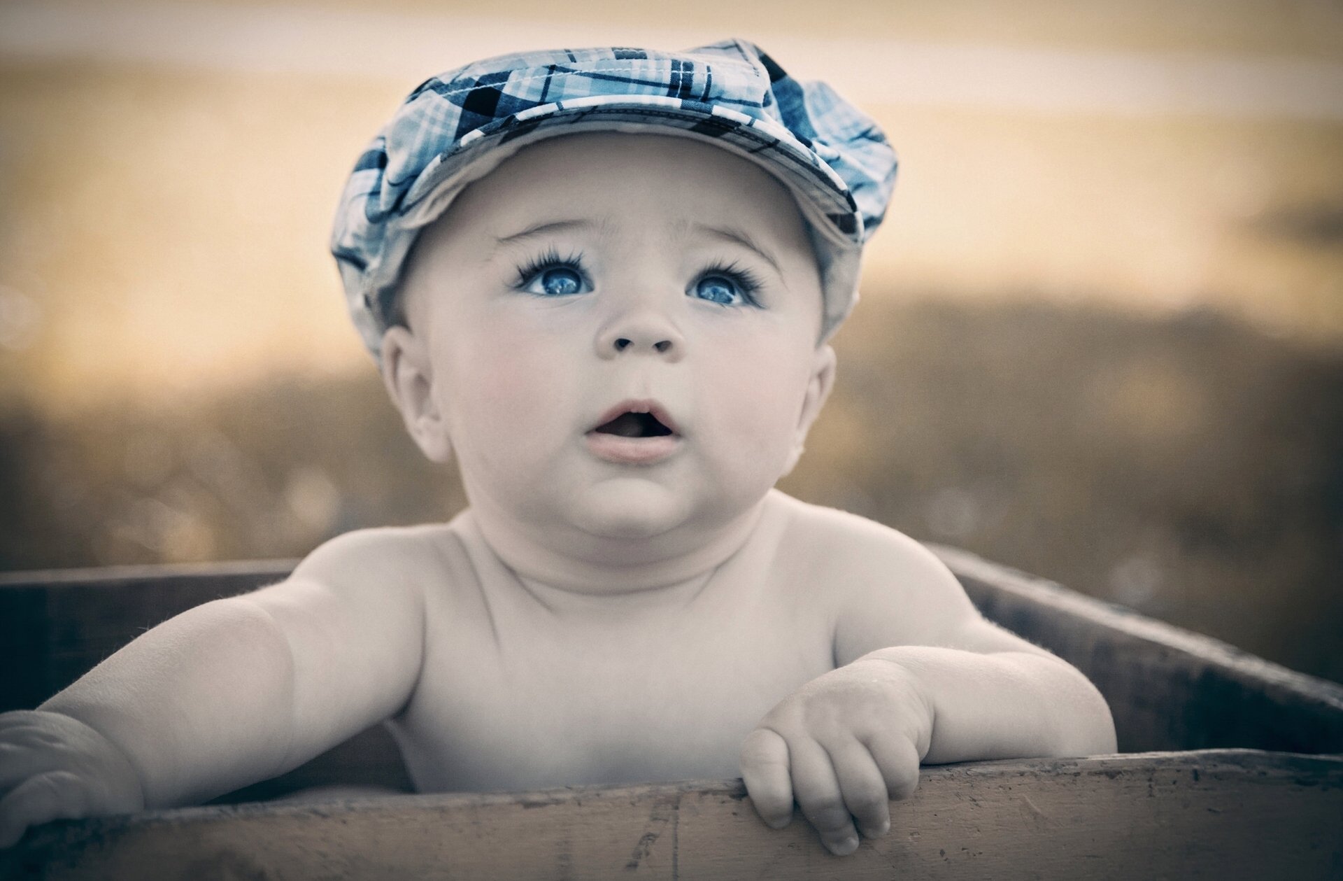 le garçon bébé yeux bleus casquette