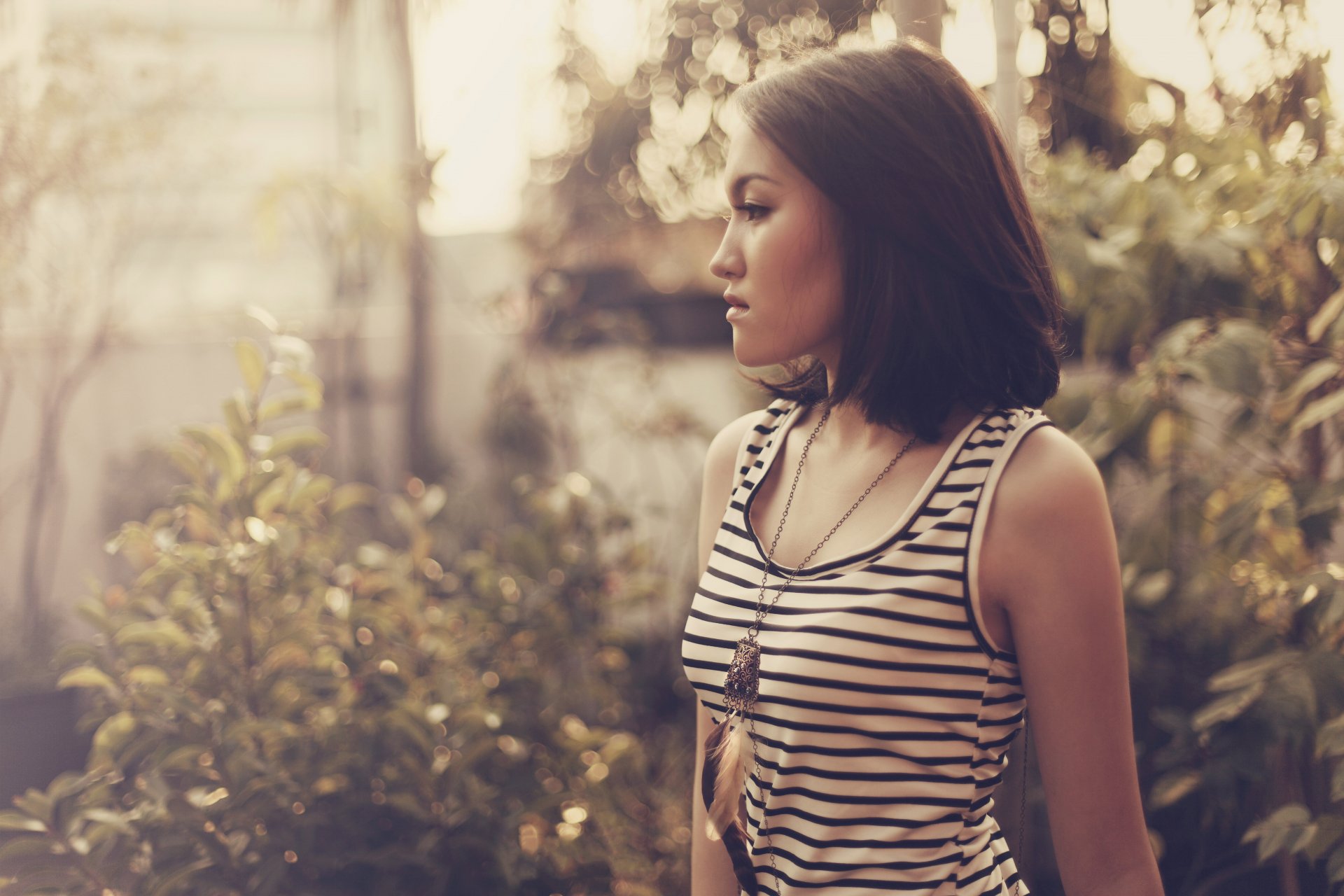 la jeune fille brune un regard un pendentif plumes
