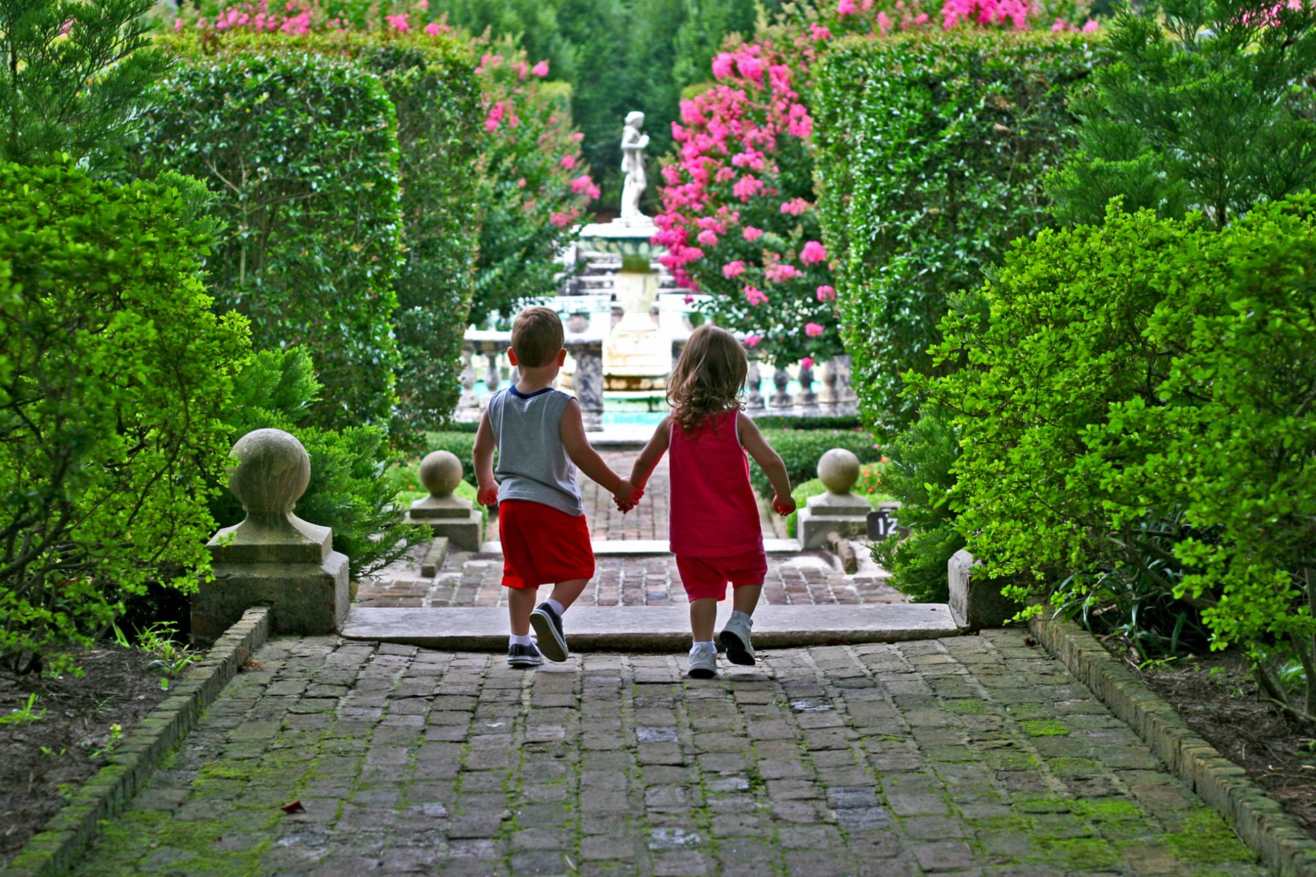 park kinder junge mädchen statue gehweg rosen blumen strauch hecke