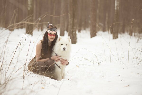 Chica con perro en el bosque de invierno