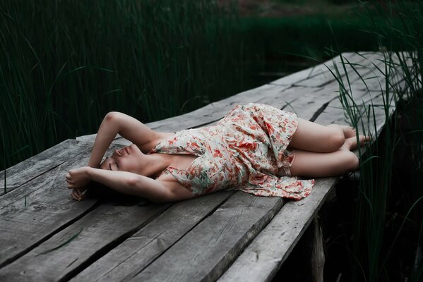 Una niña descansa en un puente sobre un río