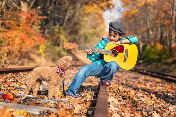 Garçon avec un caniche et une guitare jaune