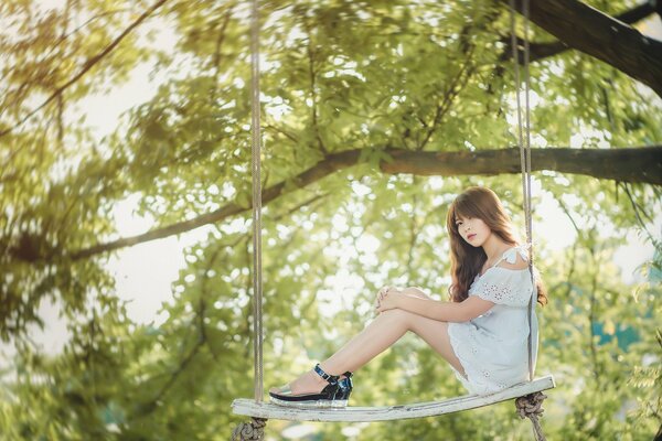 La fille sur le téléphérique de la balançoire sur un arbre